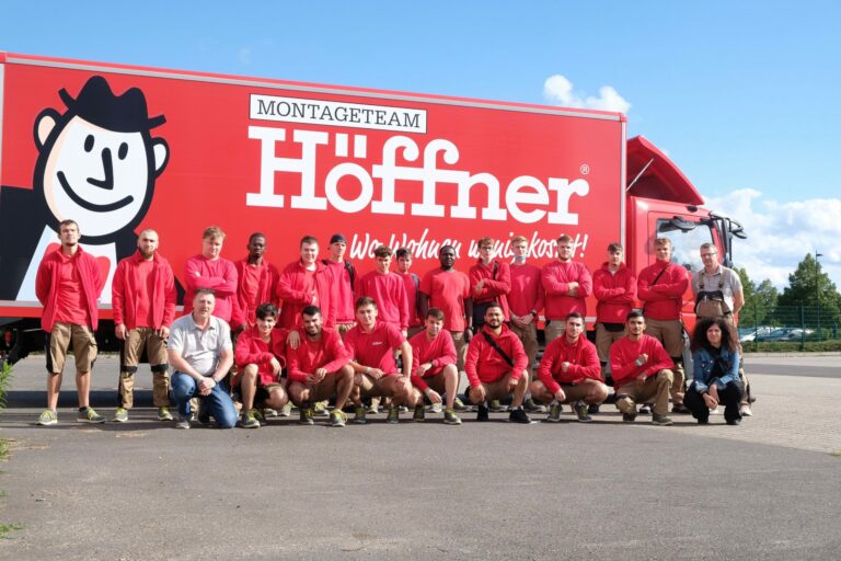 Gruppenbild der Auszubildenden vor einem Möbelwagen